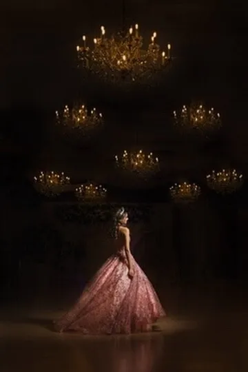 Cinematic quinceañera portrait under Nencini Ballroom chandeliers with a pink dress and dramatic spotlight